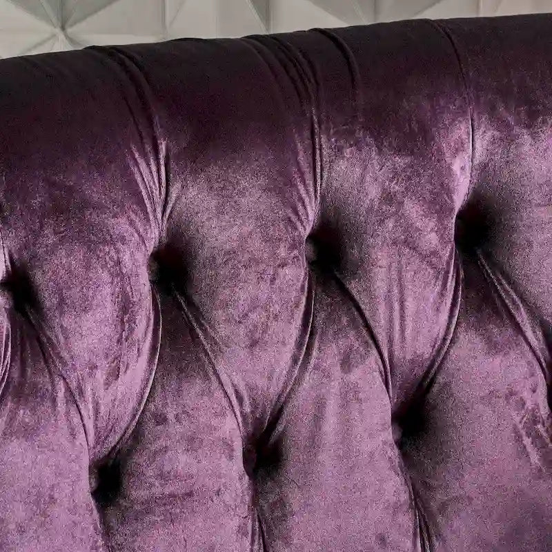 Causeuse en velours à accoudoirs arrondis et capitonnée